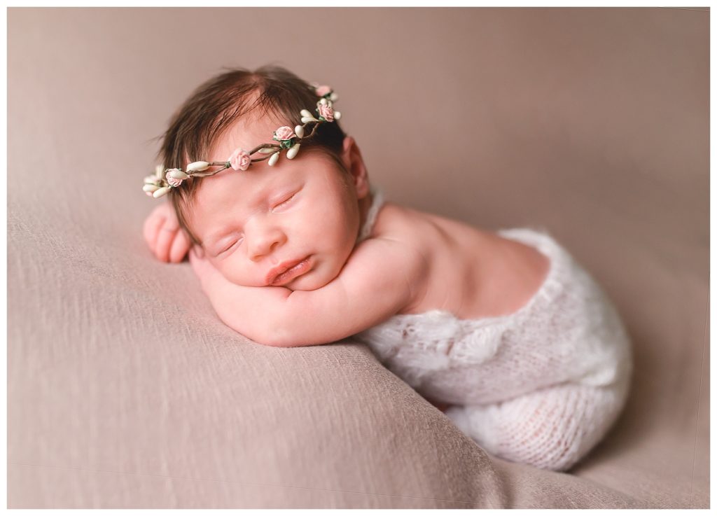 newborn baby on tan background with floral crown
