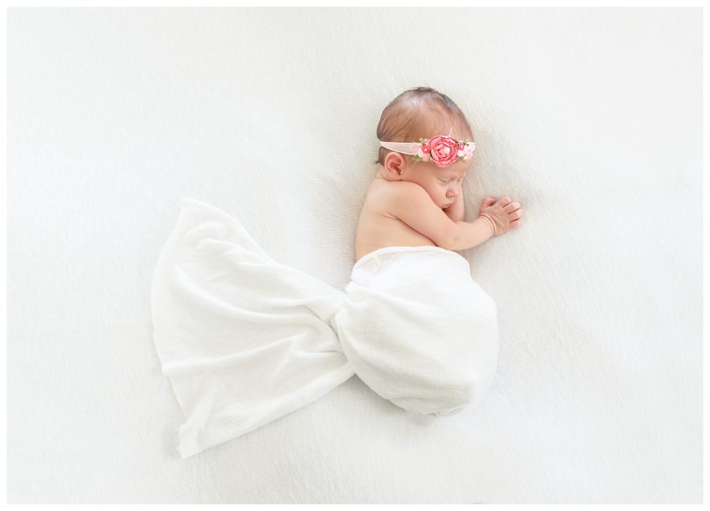 Newborn wrapped up with flower headband