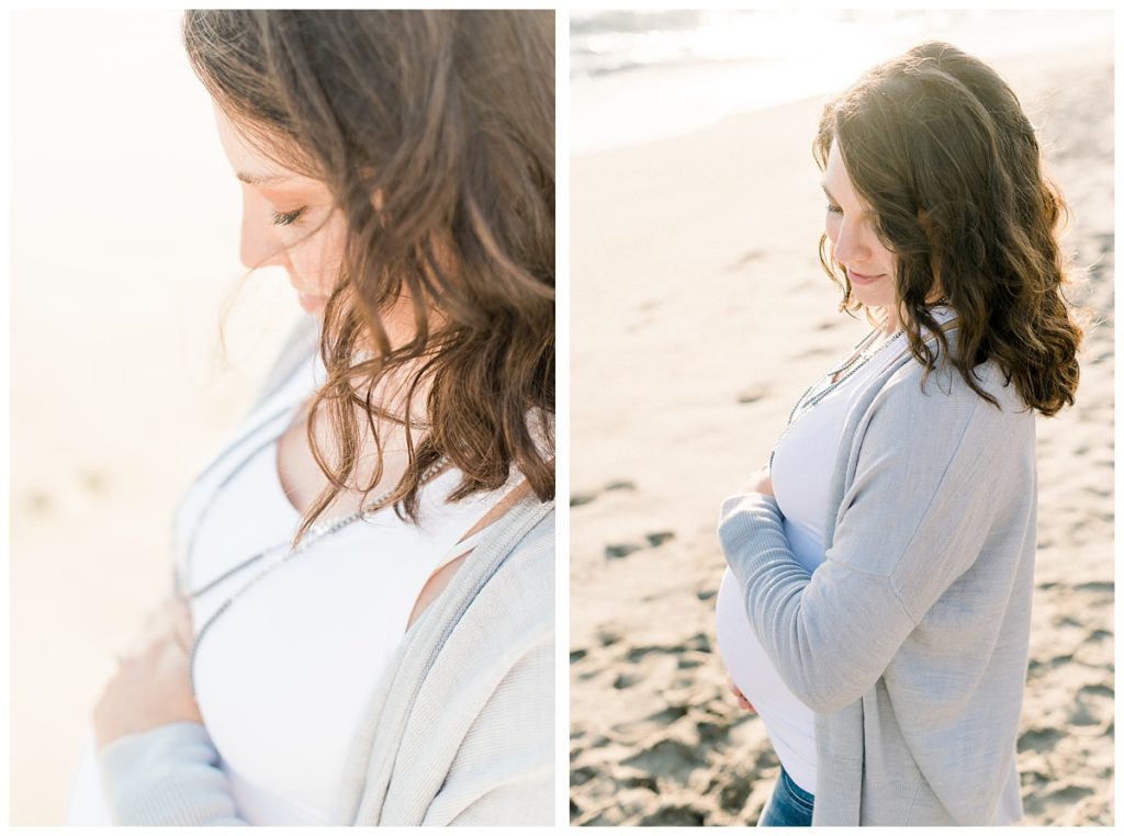 Image shows a pregnant woman at her maternity session at the beach wearing a white top with a gray sweater.