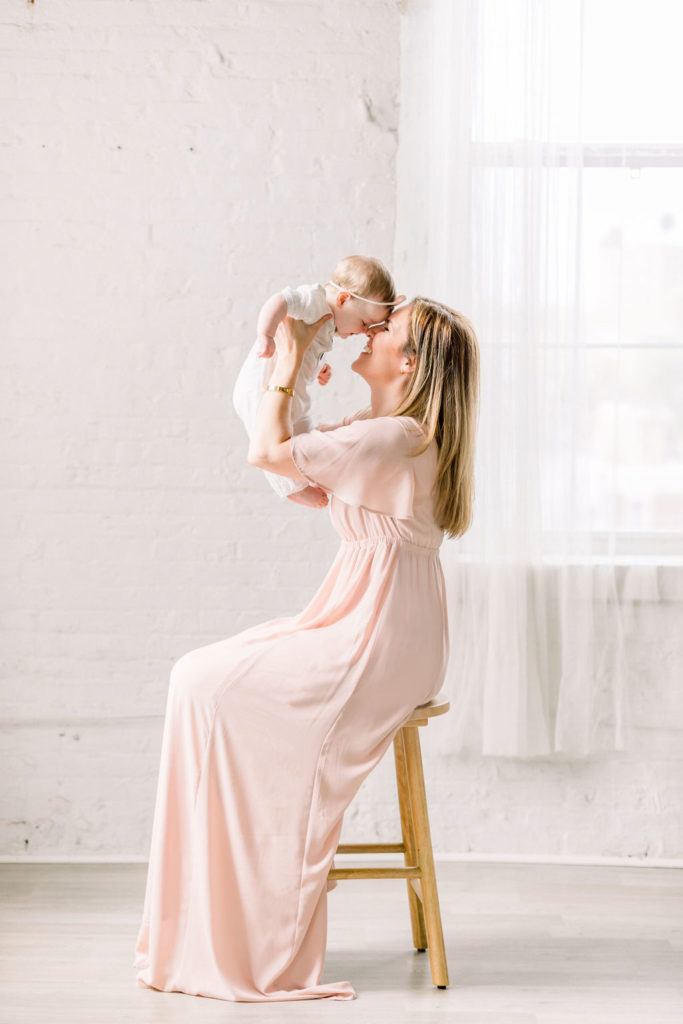 A Sweet New Jersey Motherhood Session | Kate Voda Photography a mother wearing a pink dress and her daughter in a white romper during a studio motherhood session