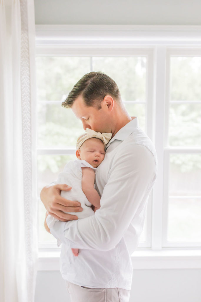 A father hugs his new baby close to his chest during a Princeton nj lifestyle newborn session