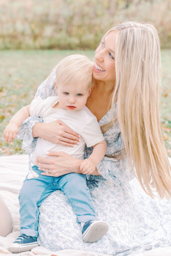 Image of Mom, and little boy sitting on a blanket at a park. This is an example of lifestyle family and newborn photography