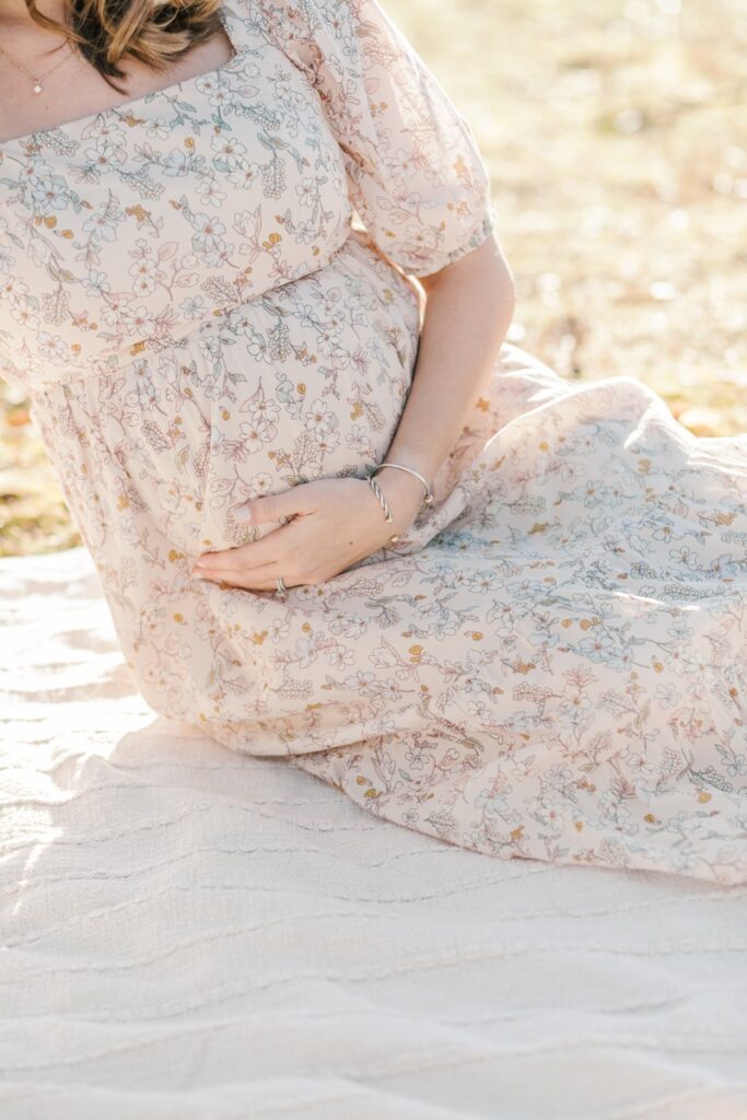A pregnant woman poses during maternity photos at Loantanka Brook Reservation