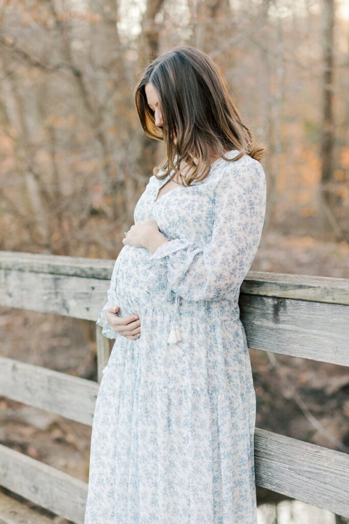 A pregnant woman poses during maternity photos at Loantanka Brook Reservation