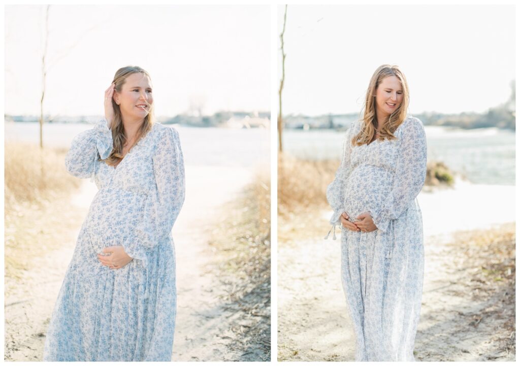 A woman wearing a long sleeve white dress with blue flowers poses during her beach maternity photos