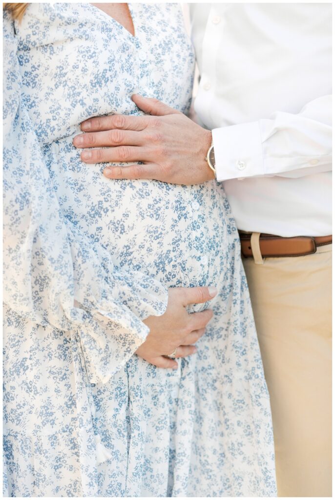 close up of a couple with their hands on the woman's pregnant belly during their beach maternity photos