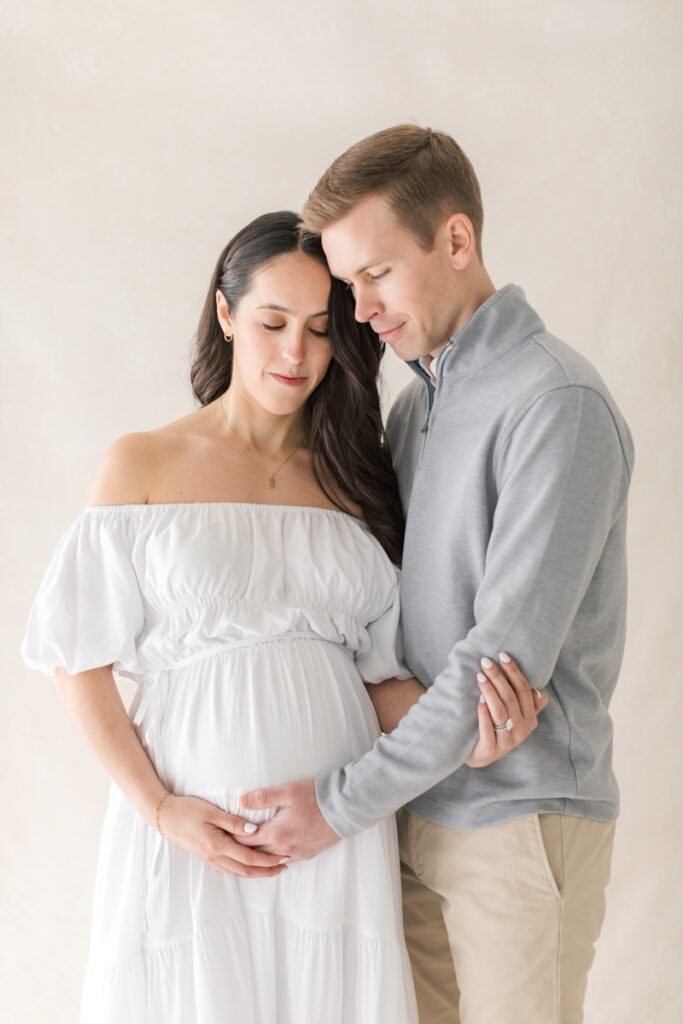 A couple holds each other during their studio maternity photos after loss