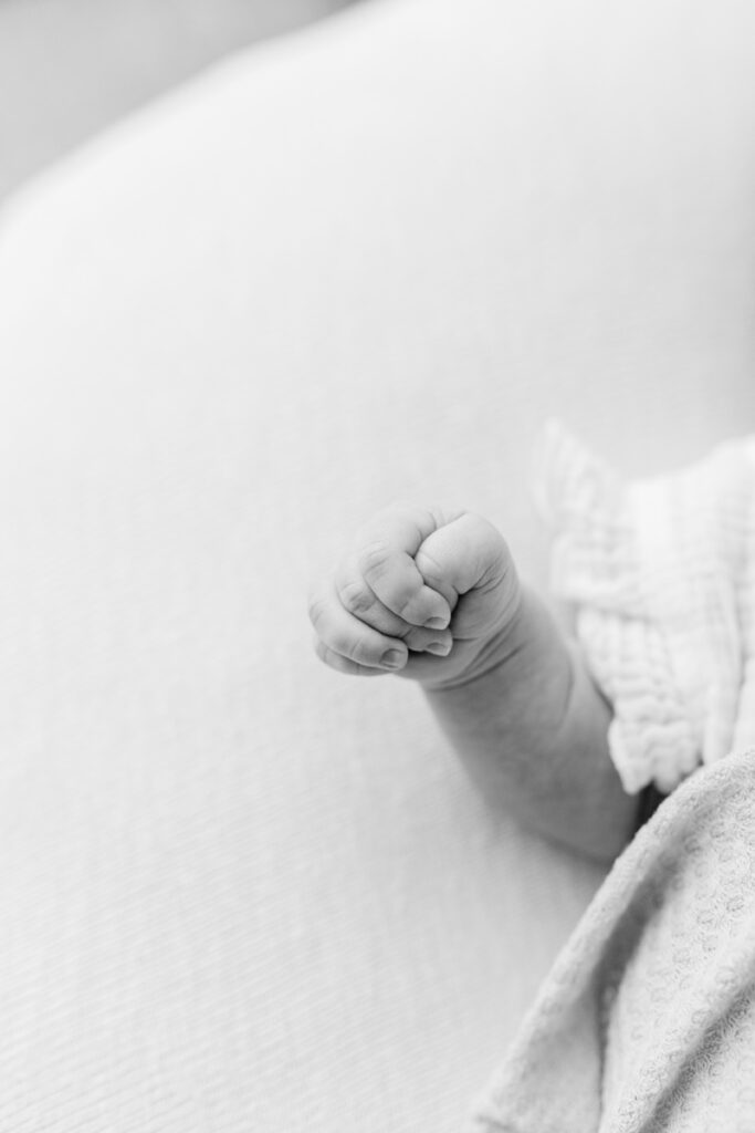 close up detail photo of a baby's hand, photographed in black and white.