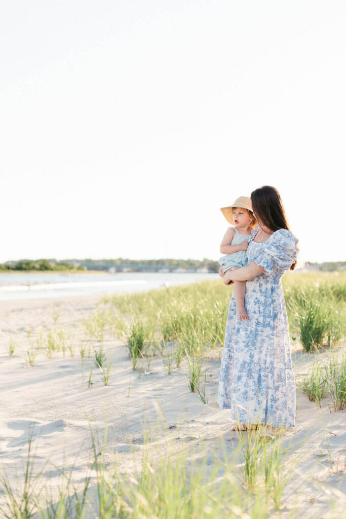 Mini Session, Half, or Full: Which Is Right for Your Family? (2026) Mom holding her toddler in a straw sun hat among the dune grass at Fisherman's Cove in Manasquan, NJ