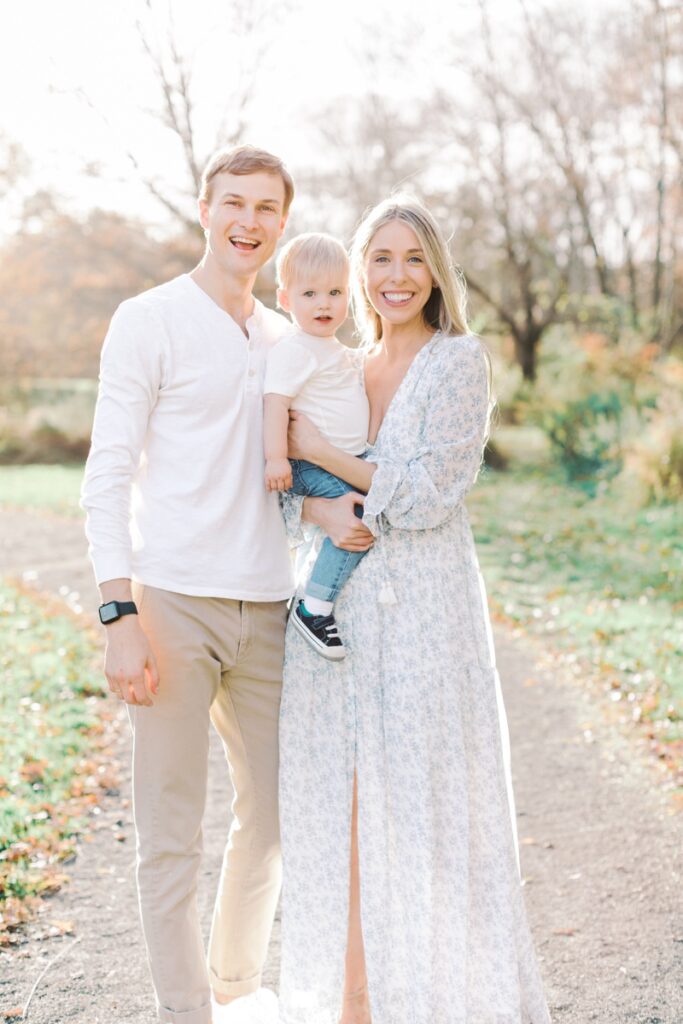 A family of three poses together during the best time of day for family photos in New Jersey