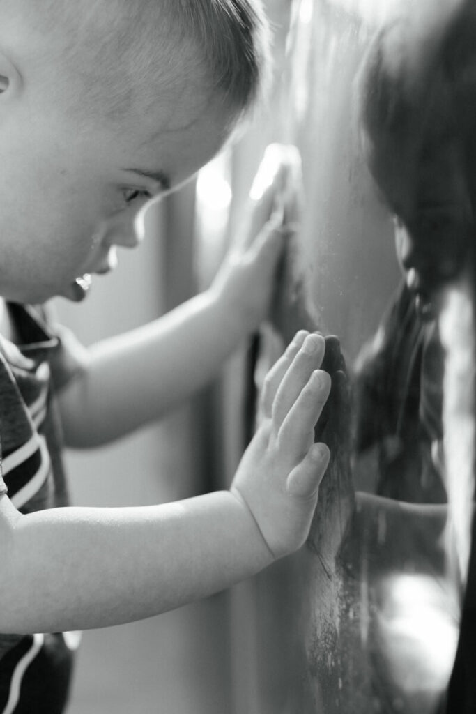 A toddler looks at his reflection