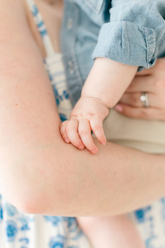 Choosing Privacy in the Age of AI Baby's hand reaching toward a parent's arm, a tender detail shot
