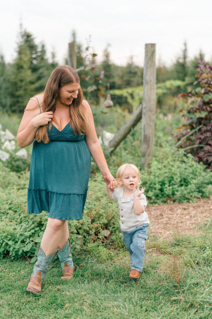Beautiful Flower Farm Family Photos | Pretty Bird Farm, NJ Mom in a teal dress walking hand in hand with her toddler son through a garden