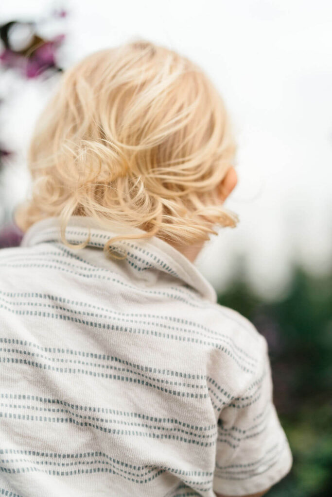 Beautiful Flower Farm Family Photos | Pretty Bird Farm, NJ Close-up of a toddler's blonde curls from behind as he looks out over the garden